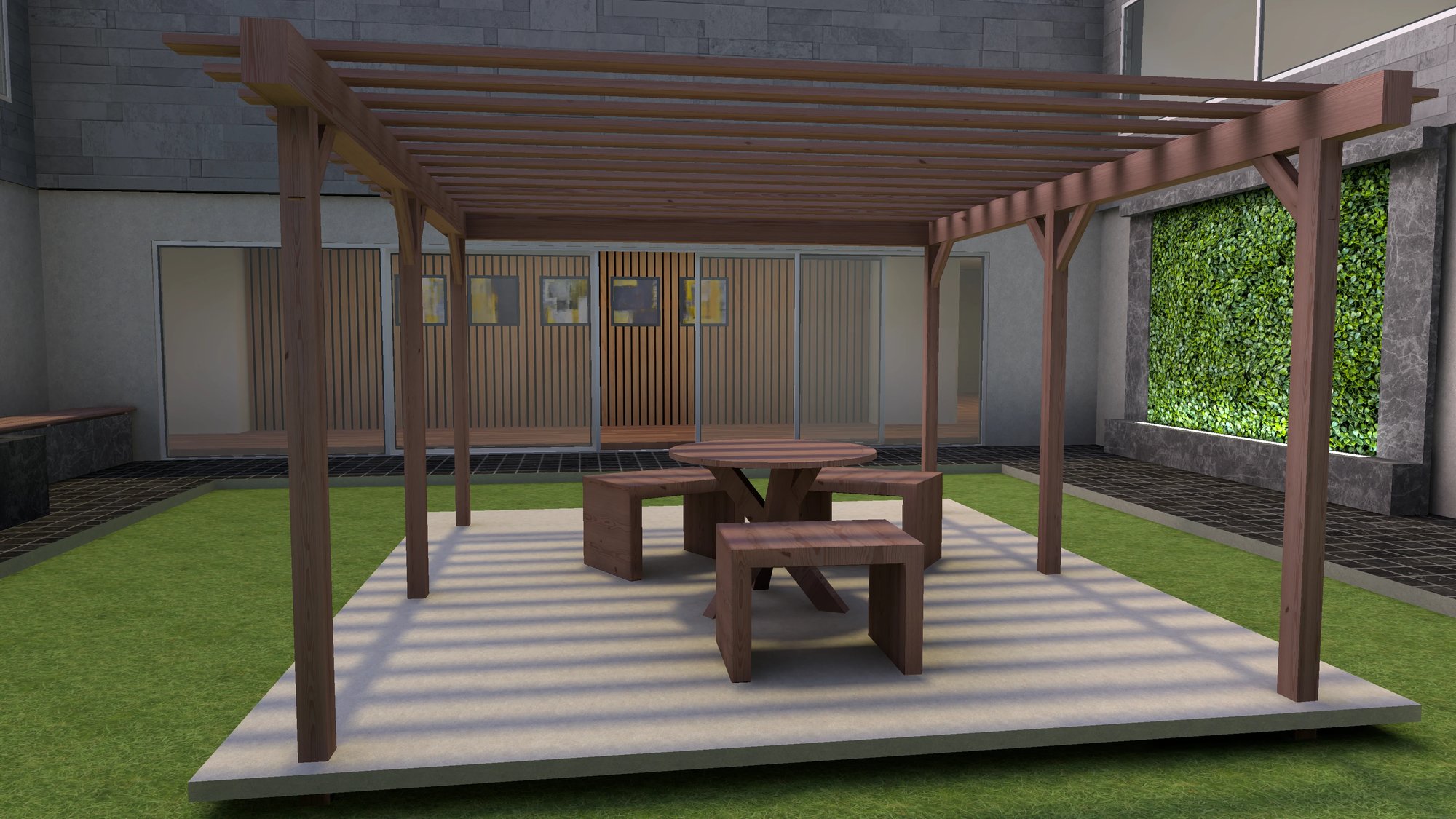 Environment, courtyard with a wooden pergola, underneath which is a round picnic table and benches on a concrete platform, and green grass surrounding the area.